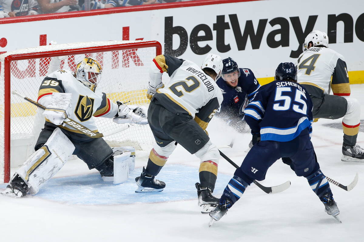 Winnipeg Jets' Nate Schmidt (88) attempts to pass out to Mark Scheifele (55) as Vegas Golden Kn ...