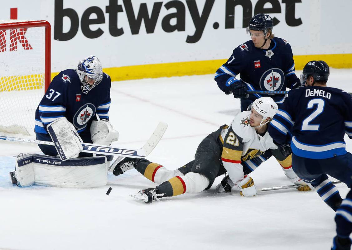 Vegas Golden Knights' Brett Howden (21) looks on as Winnipeg Jets goaltender Connor Hellebuyck ...