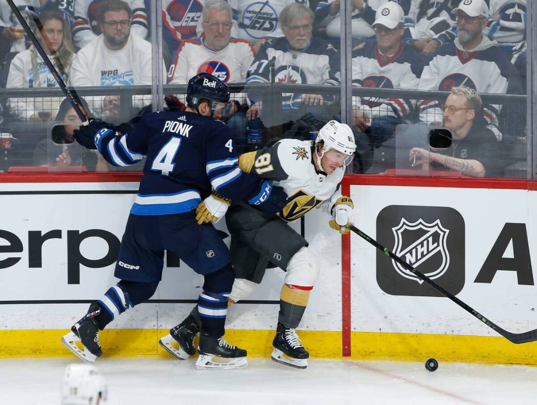 Winnipeg Jets' Neal Pionk (4) defends against Vegas Golden Knights' Jonathan Marchessault (81) ...