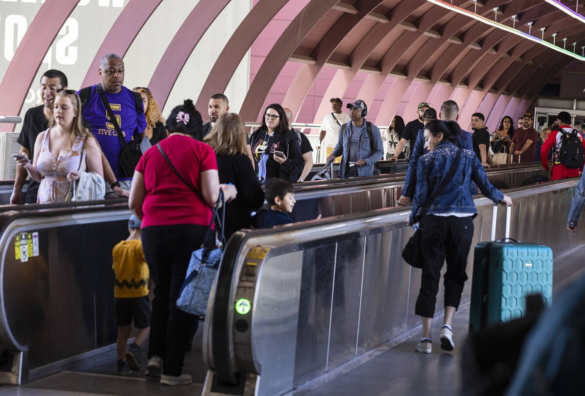 Arriving passengers head to the parking garage and Ride Share pickup location in Terminal 1 of ...