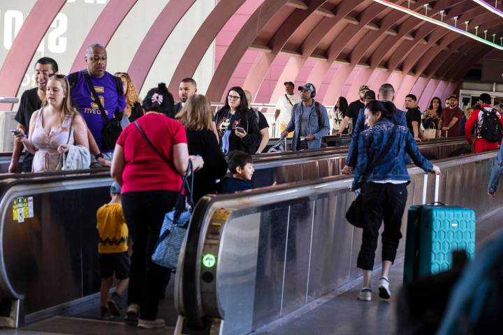 Arriving passengers head to the parking garage and Ride Share pickup location in Terminal 1 of ...