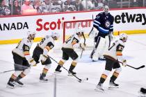 Winnipeg Jets' goaltender Connor Hellebuyck (37) looks on as the Vegas Golden Knights celebrate ...