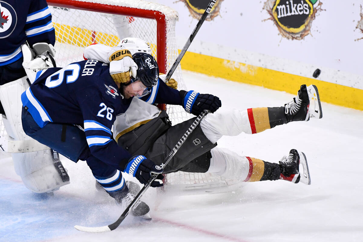 Vegas Golden Knights' Brett Howden (21) and Winnipeg Jets' Blake Wheeler (26) collide during th ...