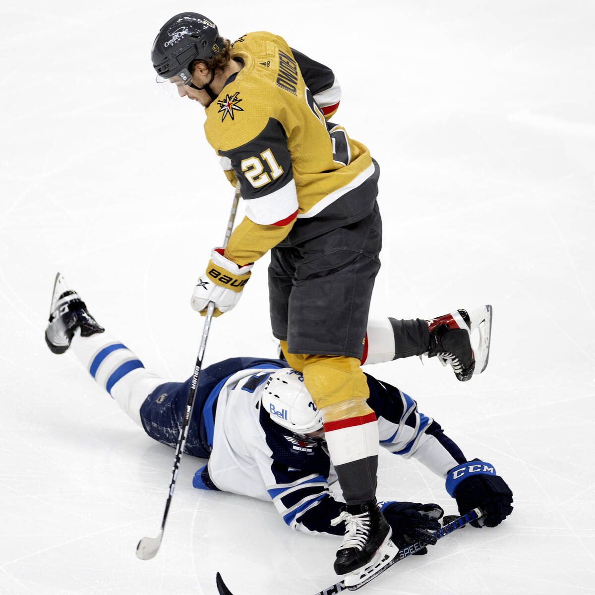 Golden Knights center Brett Howden (21) collides with Winnipeg Jets defenseman Dylan DeMelo (2) ...