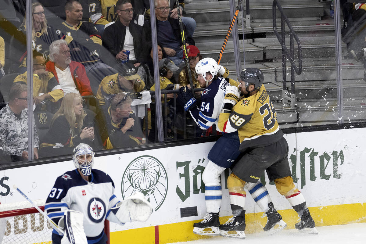 Golden Knights left wing William Carrier (28) flames Winnipeg Jets defenseman Dylan Samberg (54 ...