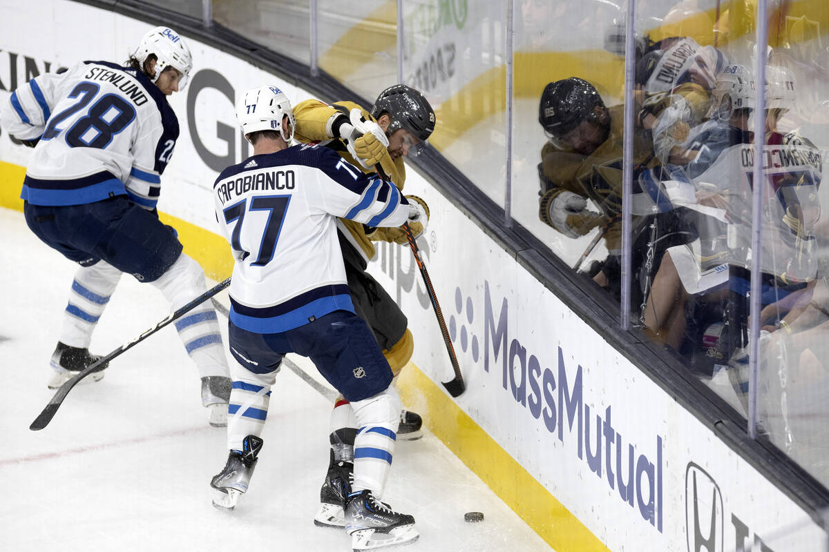 Golden Knights left wing William Carrier (28) battles for the puck with Winnipeg Jets defensema ...