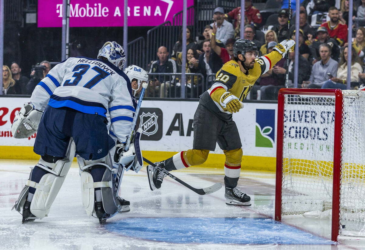 Golden Knights center Chandler Stephenson (20) scores the first goal over Winnipeg Jets goalten ...