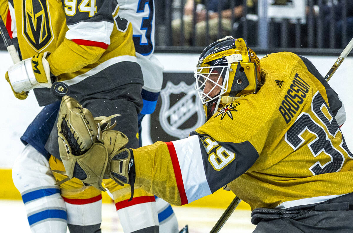 Golden Knights goaltender Laurent Brossoit (39) grabs at a puck against the Winnipeg Jets durin ...