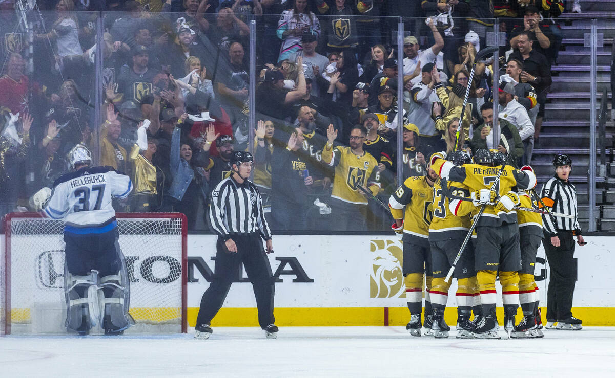 The Golden Knights celebrate another goal over Winnipeg Jets goaltender Connor Hellebuyck (37) ...