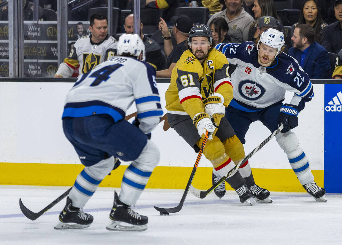 Golden Knights right wing Mark Stone (61) controls the puck between Winnipeg Jets defenseman Dy ...