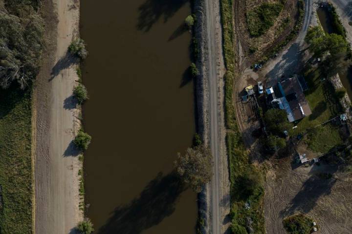 A home sits next to the North Fork Kings River in the Island District of Lemoore, Calif., Wedne ...