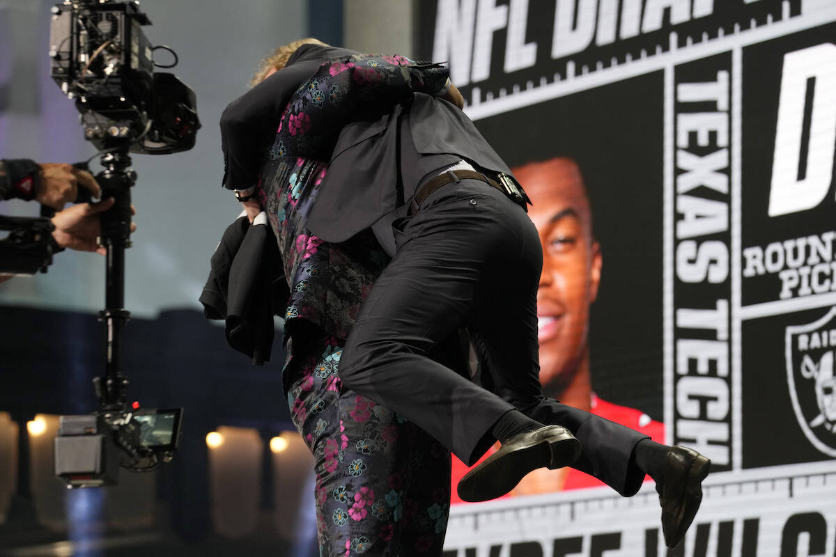 Texas Tech edge rusher Tyree Wilson, left, picks up and hugs Roger Goodell, NFL Commissioner, a ...