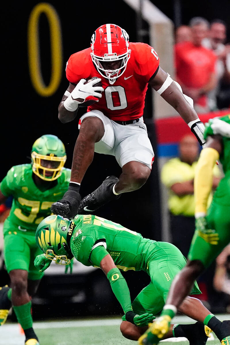 Georgia tight end Darnell Washington (0) hurdles Oregon defensive back Bryan Addison (13) after ...