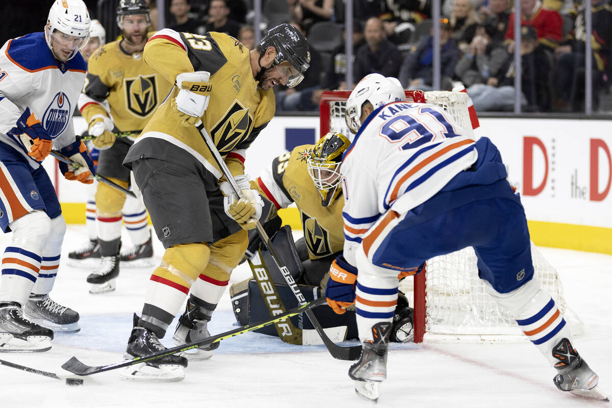 Golden Knights goaltender Laurent Brossoit (39) prepares to make a save while Knights defensema ...