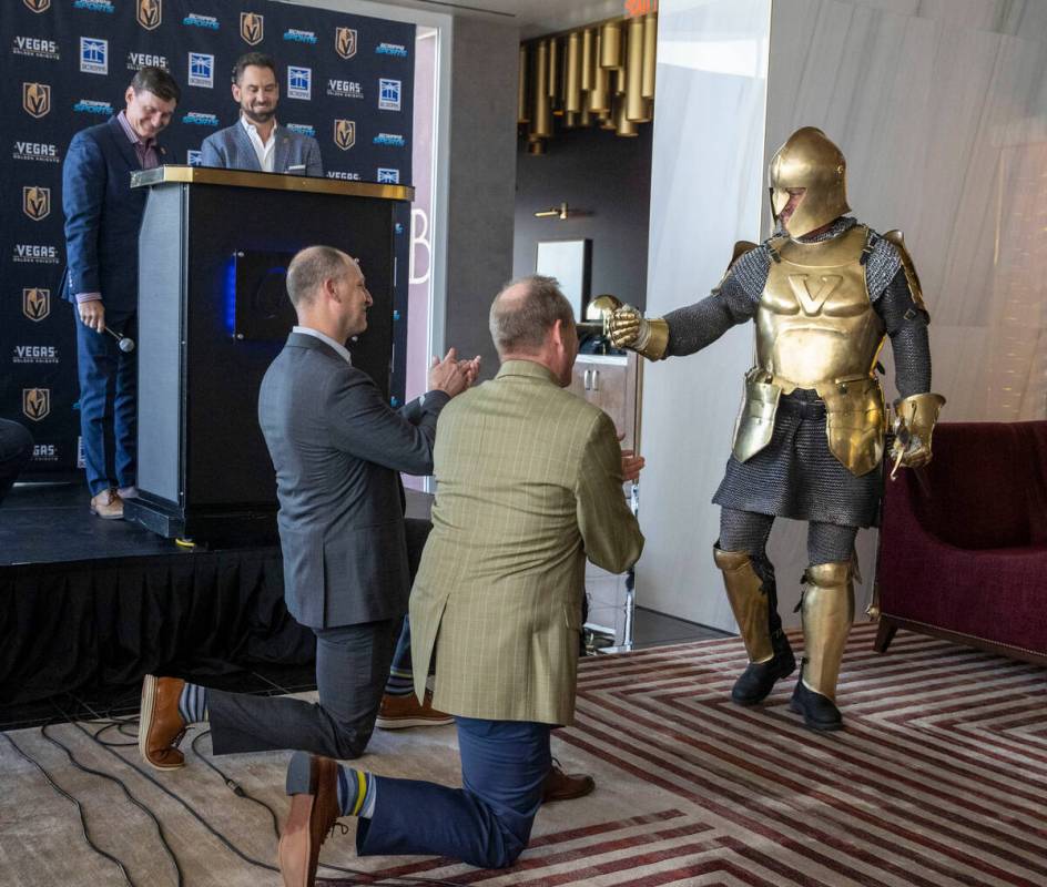 Lee the Golden Knight, right, knights Scripps Company CEO Adam Symson, center, and Scripps Spor ...