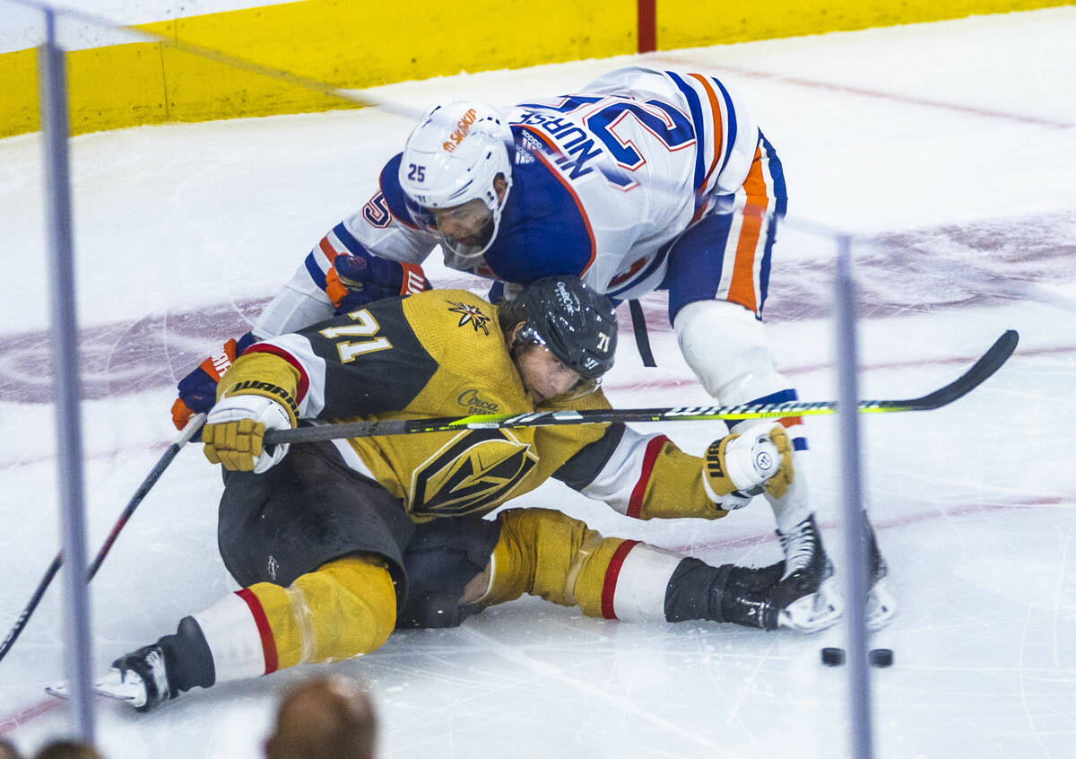 Golden Knights center William Karlsson (71) is pushed down to the ice by Edmonton Oilers defens ...