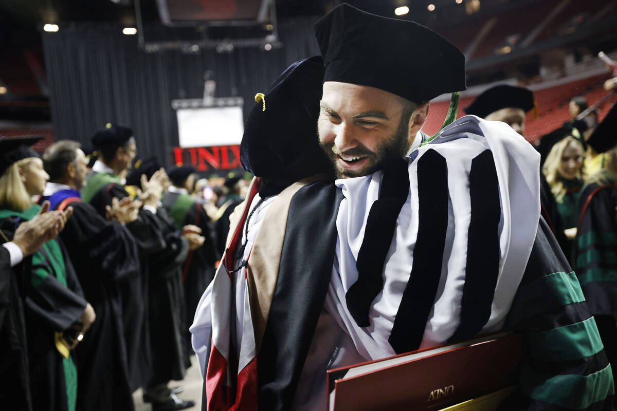 James Clark receives a hug from Carol Del Carlo, a member of Nevada System of Higher Education ...