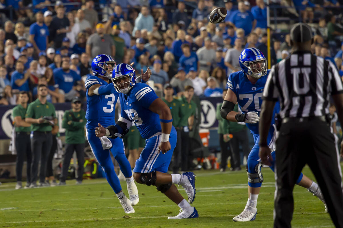 Brigham Young Cougars quarterback Jaren Hall (3) catches the football behind offensive lineman ...