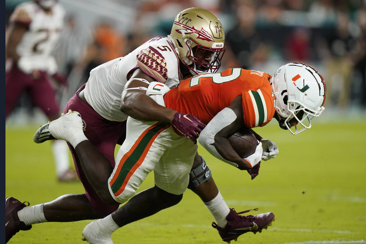 Florida State defensive lineman Jared Verse (5) tackles Miami wide receiver Brashard Smith (12) ...