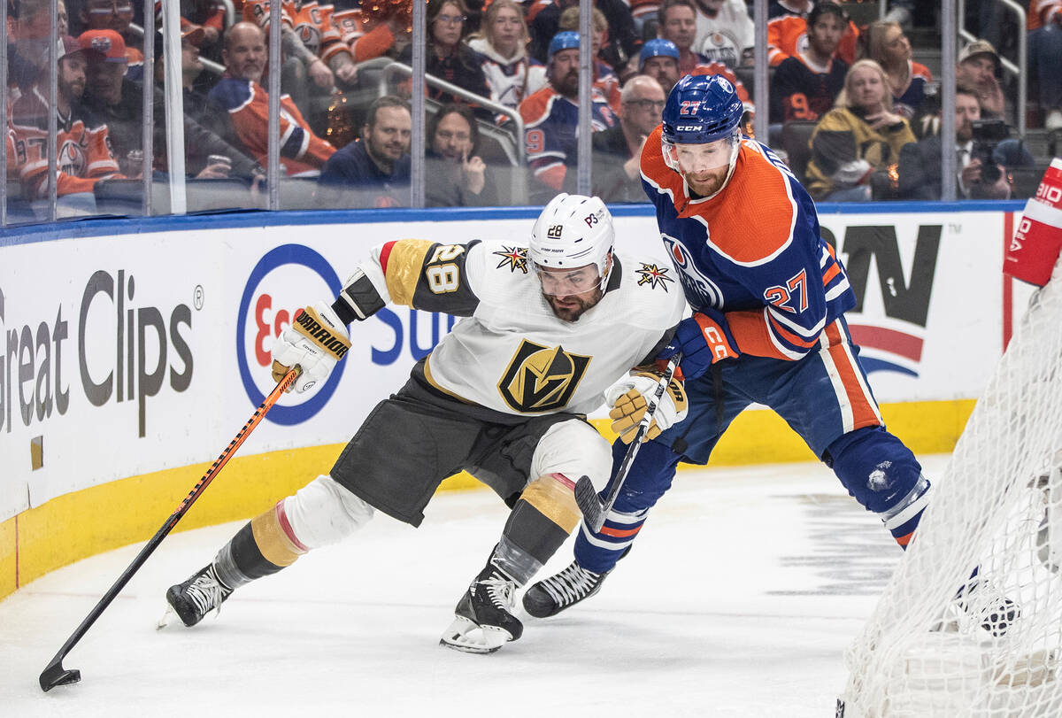 Vegas Golden Knights' William Carrier (28) and Edmonton Oilers' Brett Kulak (27) vie for the pu ...