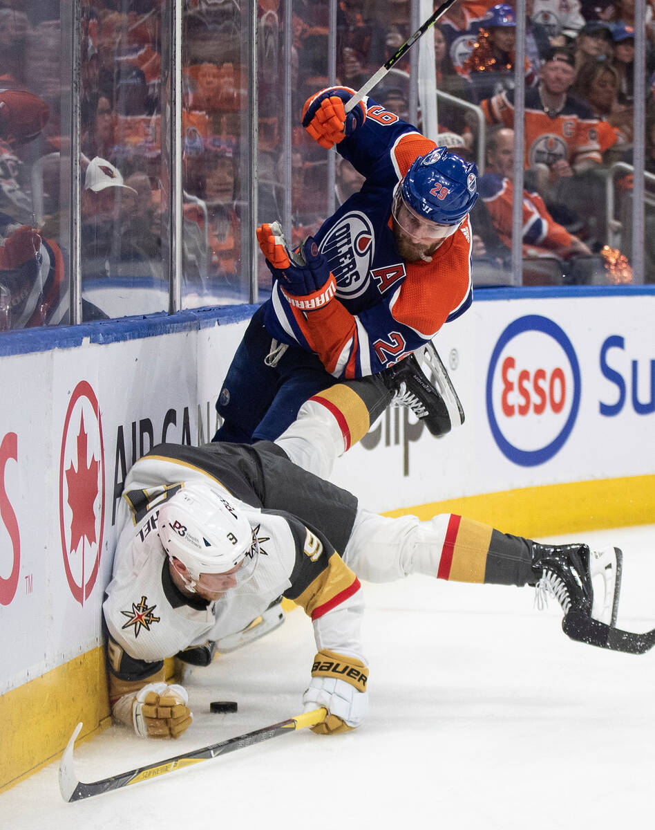 Vegas Golden Knights' Jack Eichel (9) is checked by Edmonton Oilers' Leon Draisaitl (29) during ...