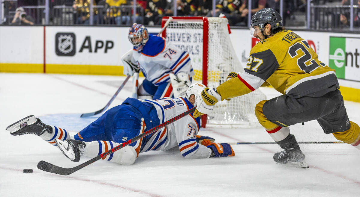 Golden Knights defenseman Shea Theodore (27) battles for control of the puck over Edmonton Oile ...