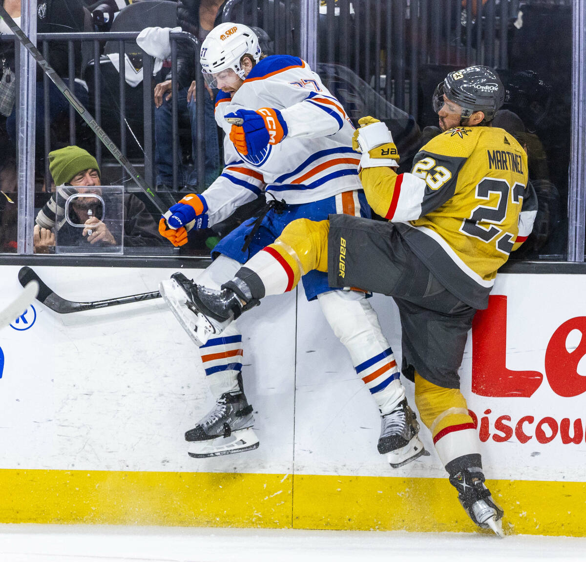 Golden Knights defenseman Alec Martinez (23) checks Edmonton Oilers left wing Warren Foegele (3 ...