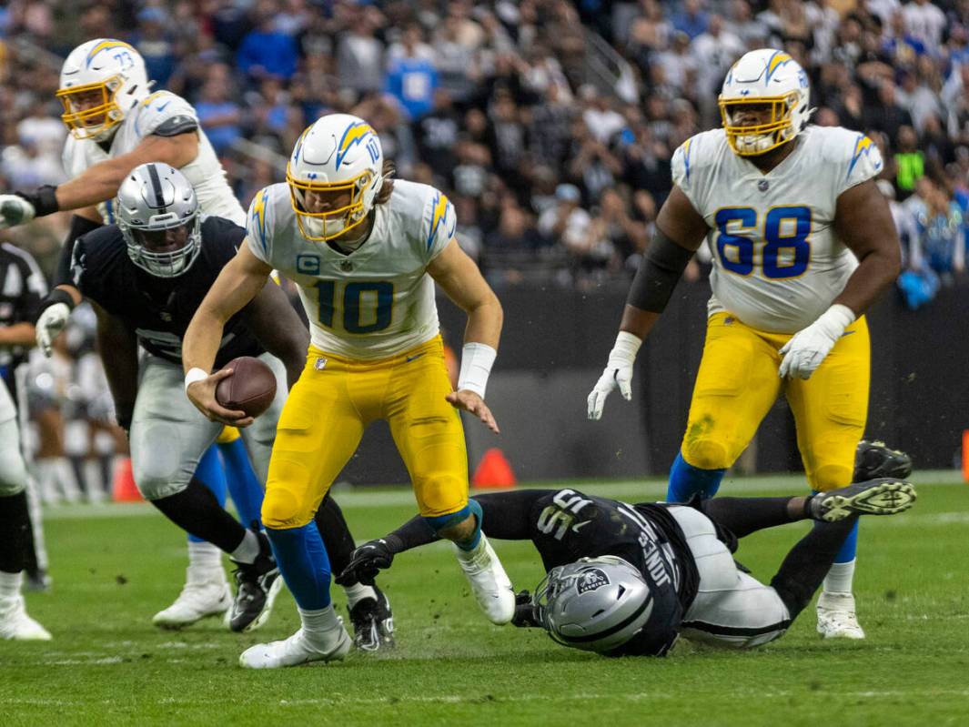 Raiders defensive end Chandler Jones (55) wraps up Los Angeles Chargers quarterback Justin Herb ...