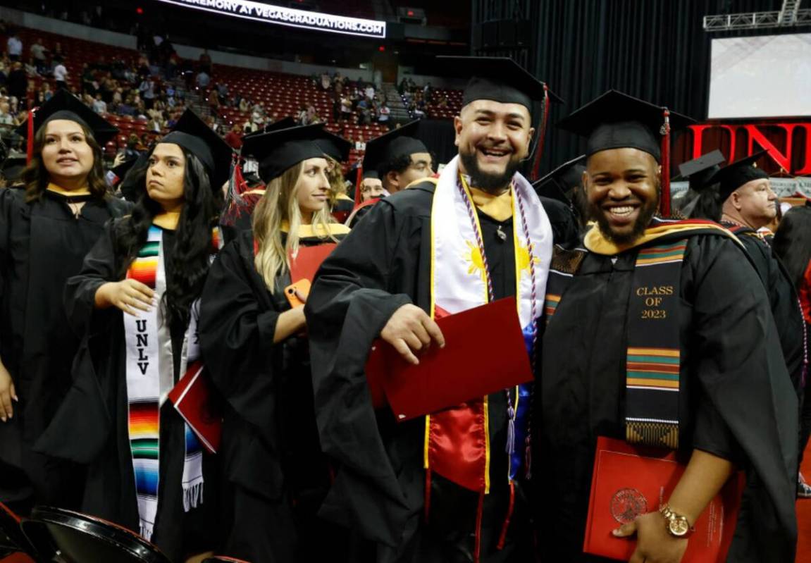 Graduates Joseph Walker, right, and Michael Fowler, left, smile after UNLV commencement ceremon ...