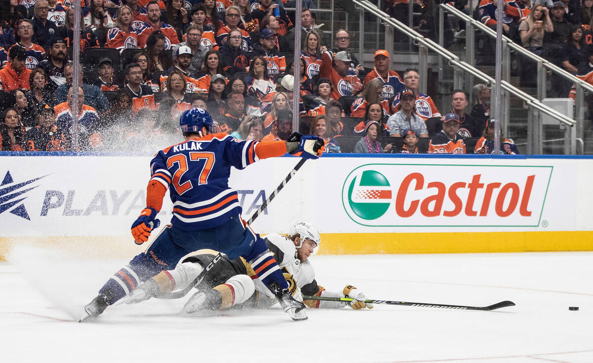 Vegas Golden Knights' William Karlsson (71) and Edmonton Oilers' Brett Kulak (27) battle for th ...