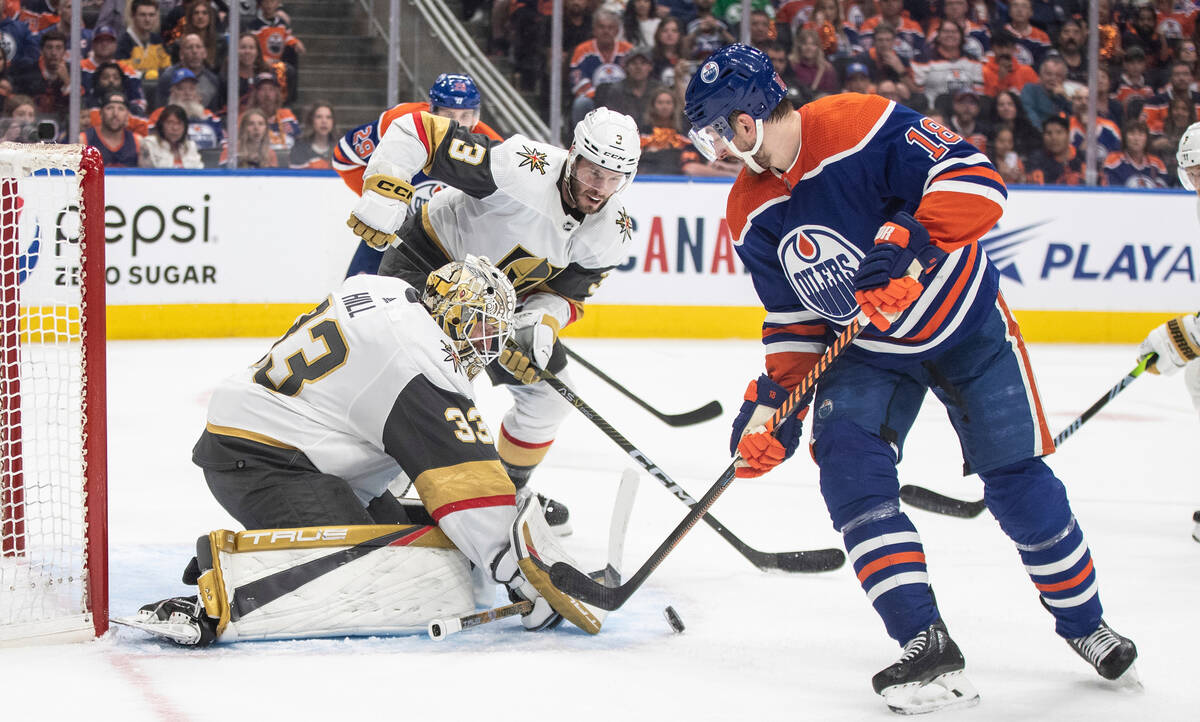 Vegas Golden Knights goalie Adin Hill (33) makes the save on Edmonton Oilers' Zach Hyman (18) a ...