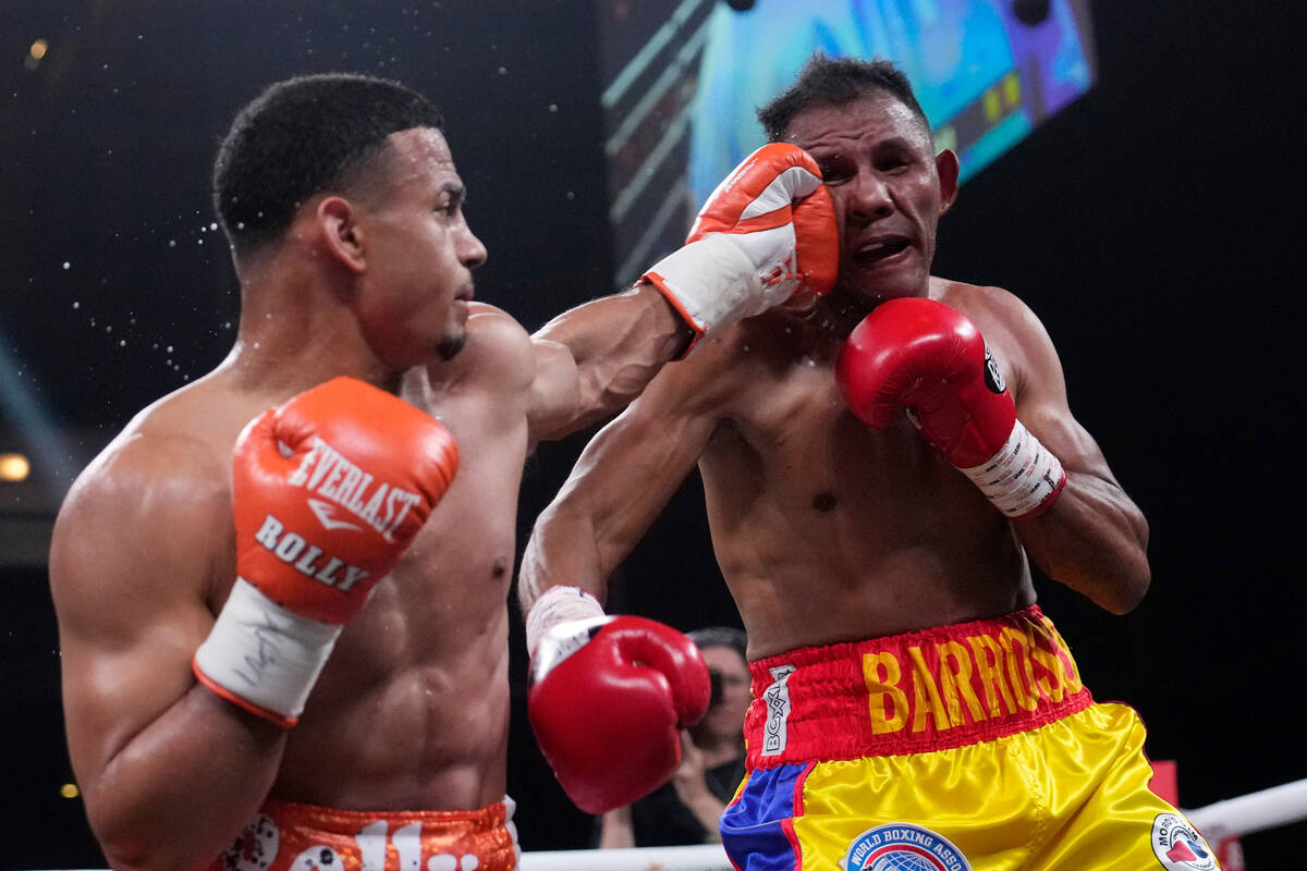 Rolando Romero punches Ismael Barroso in a super lightweight title boxing match Saturday, May 1 ...