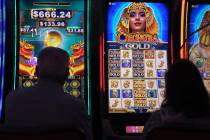 Gamblers are silhouetted against the light from slot machines on Aug. 8,2022 at the Hard Rock c ...