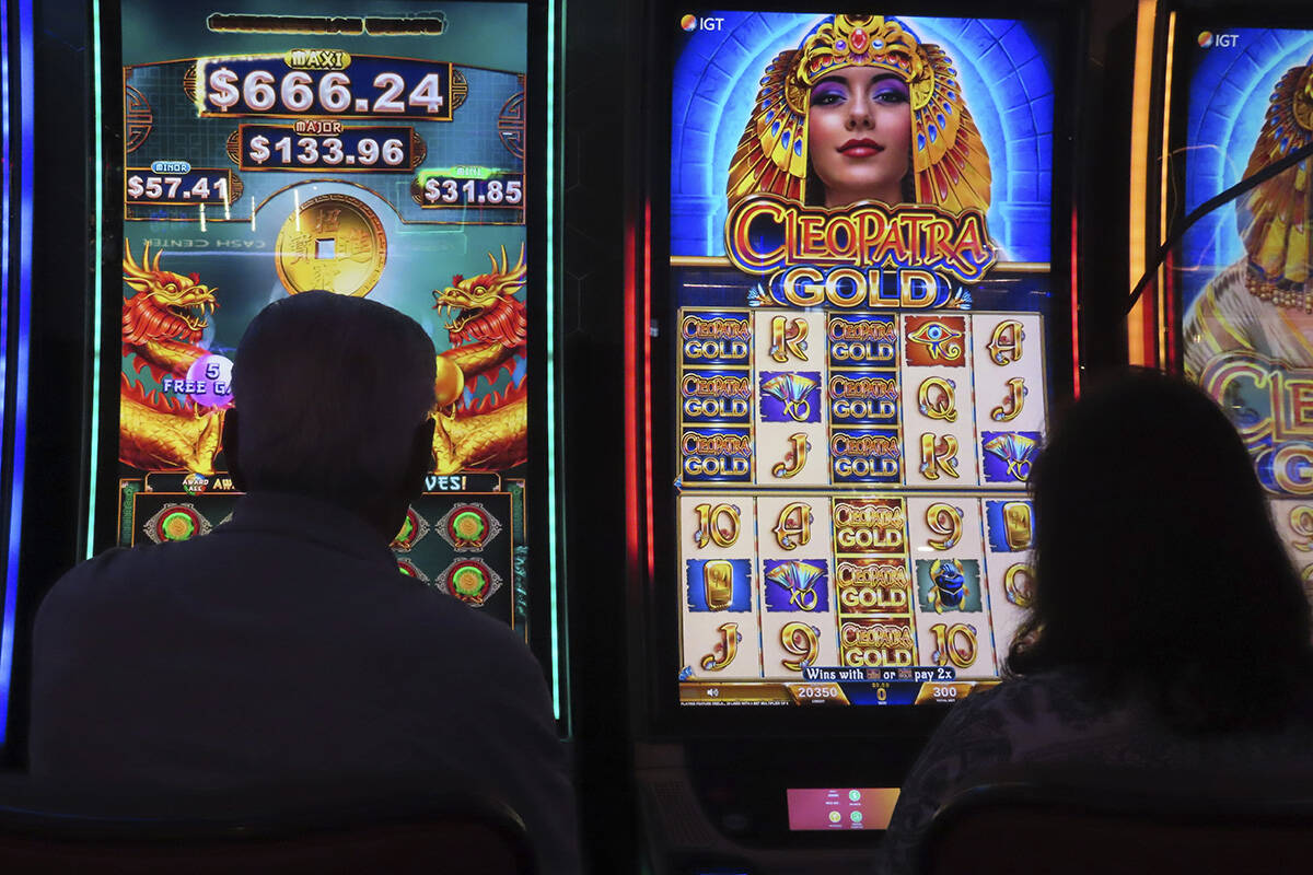 Gamblers are silhouetted against the light from slot machines on Aug. 8,2022 at the Hard Rock c ...