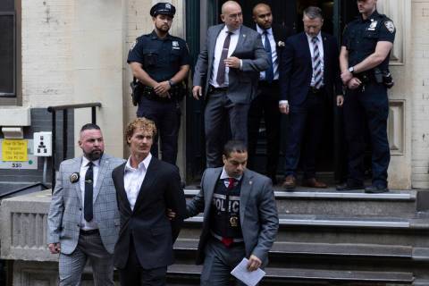 Daniel Penny, center, is walked by New York Police Department detectives detectives out of the ...