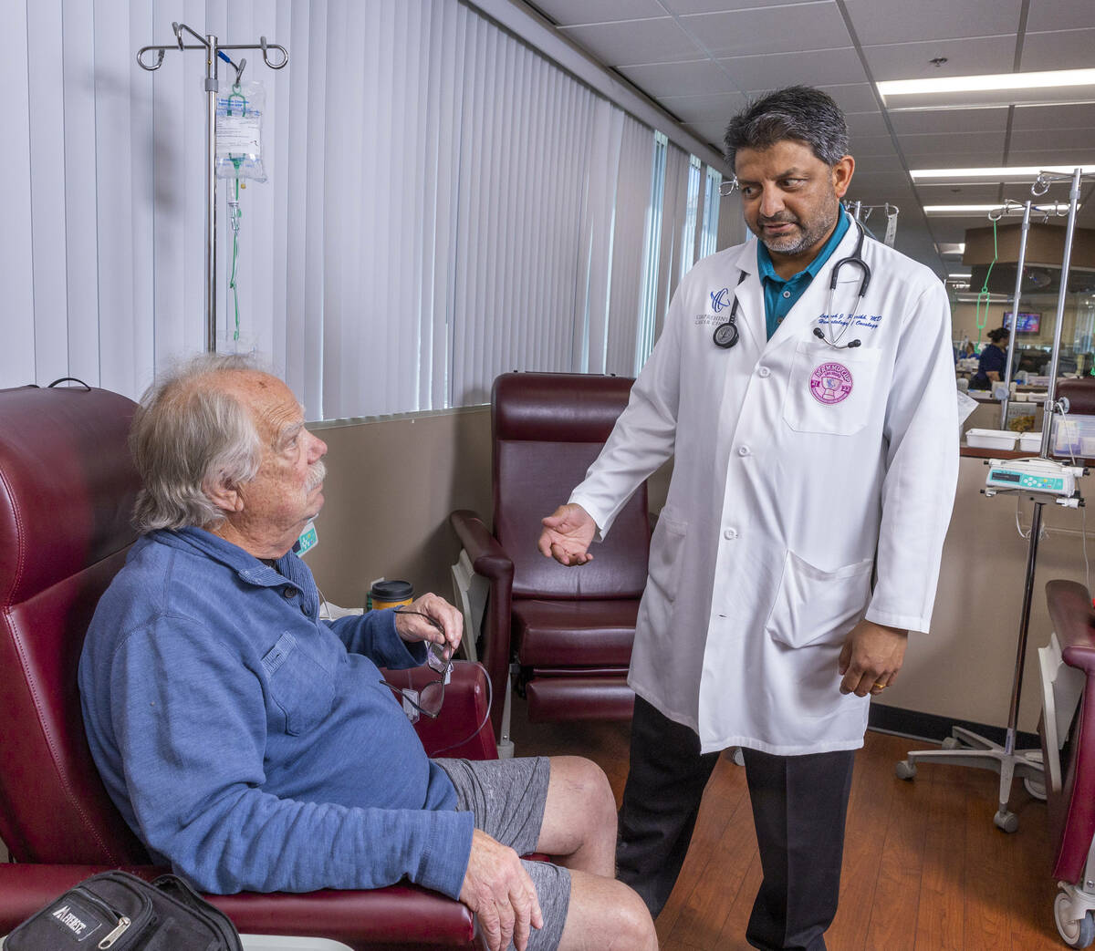 Dr. Rupesh Parikh, right, chats with patient Scott Long of Las Vegas in the chemo treatment roo ...