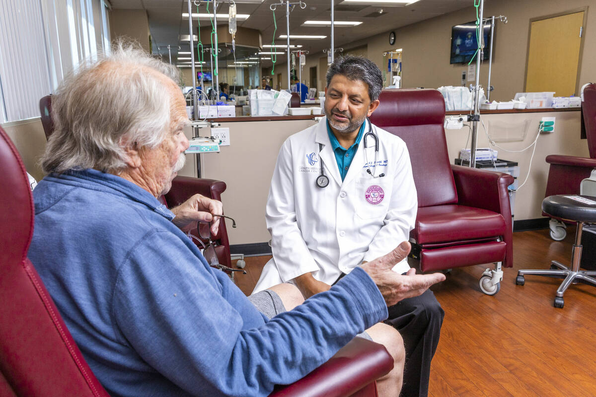 Dr. Rupesh Parikh, right, chats with patient Scott Long of Las Vegas in the chemo treatment roo ...