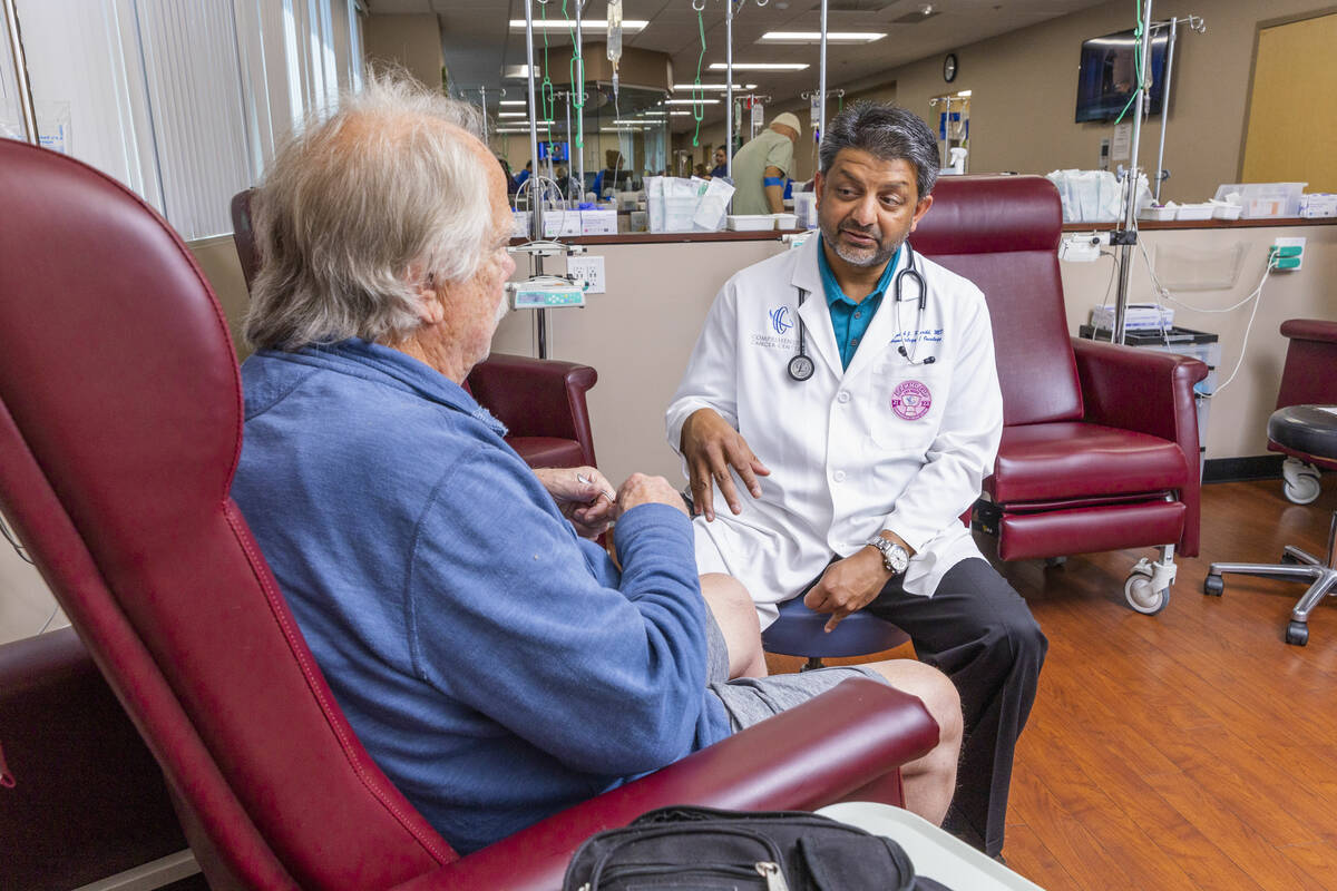 Dr. Rupesh Parikh, right, chats with patient Scott Long of Las Vegas in the chemo treatment roo ...