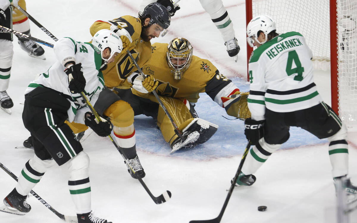 Dallas Stars defenseman Miro Heiskanen (4) and Dallas Stars left wing Jamie Benn (14) try to sh ...