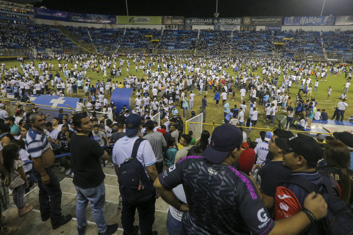Fans take to the field of Cuscatlan stadium in San Salvador, El Salvador, Saturday, May 20, 202 ...
