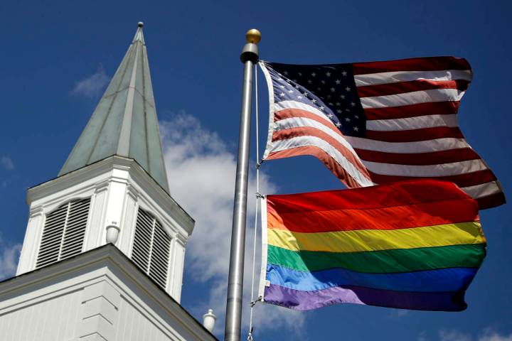 FILE - In this April 19, 2019, file photo, a gay pride rainbow flag flies along with the U.S. f ...