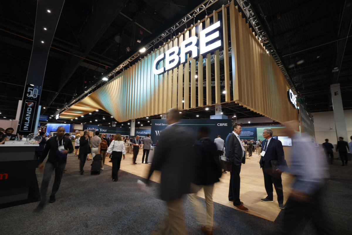 People walk by the CBRE booth at Las Vegas Convention Center, Tuesday, May 23, 2023. (Chitose S ...