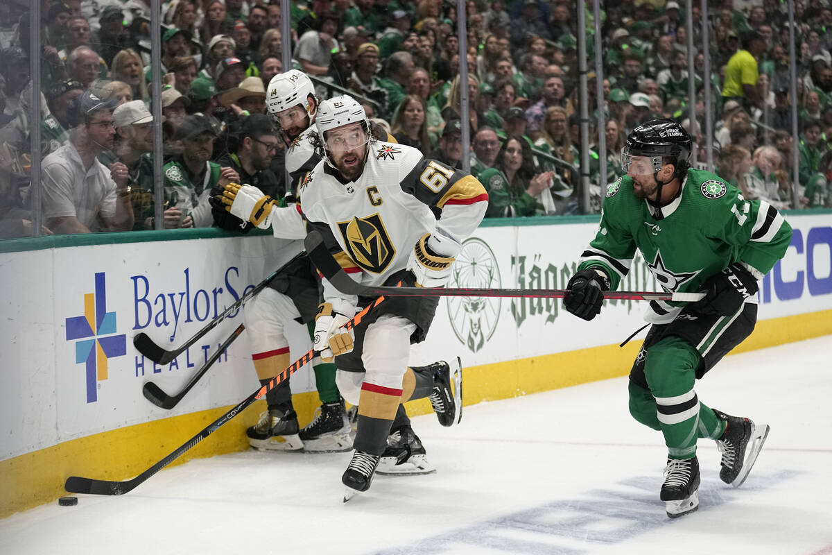 Vegas Golden Knights right wing Mark Stone (61) attempts to clear the puck from behind the team ...