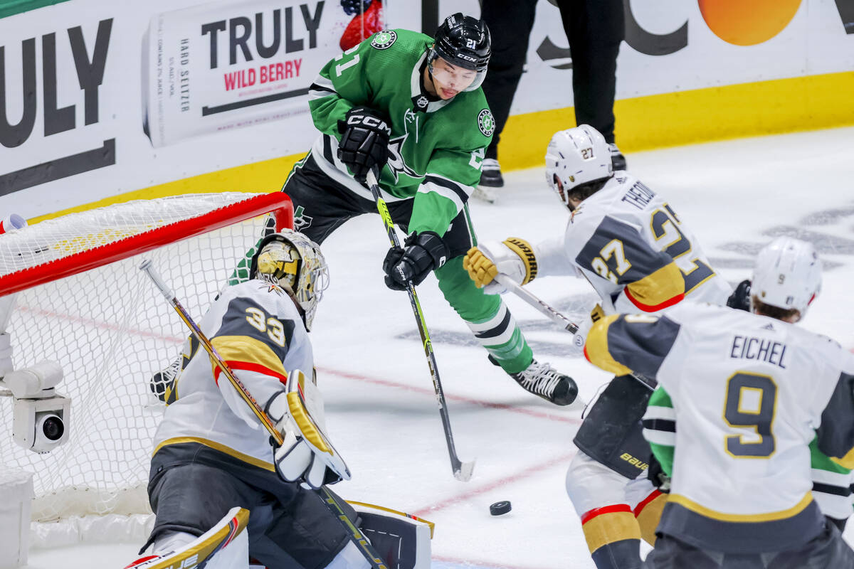 Dallas Stars left wing Jason Robertson, center, shoots as Vegas Golden Knights goalie Adin Hill ...