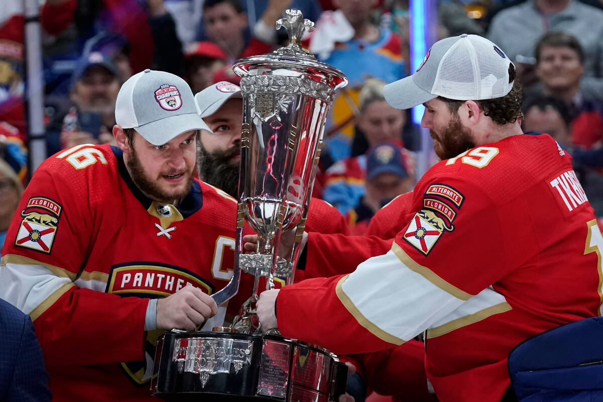 Florida Panthers center Aleksander Barkov, left and left wing Matthew Tkachuk, right, hold up t ...