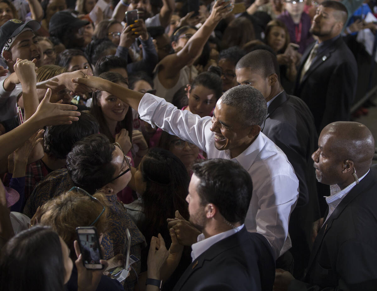 Former President Barack Obama, right, shakes hands with the crowd at Cox Pavilion after a rally ...