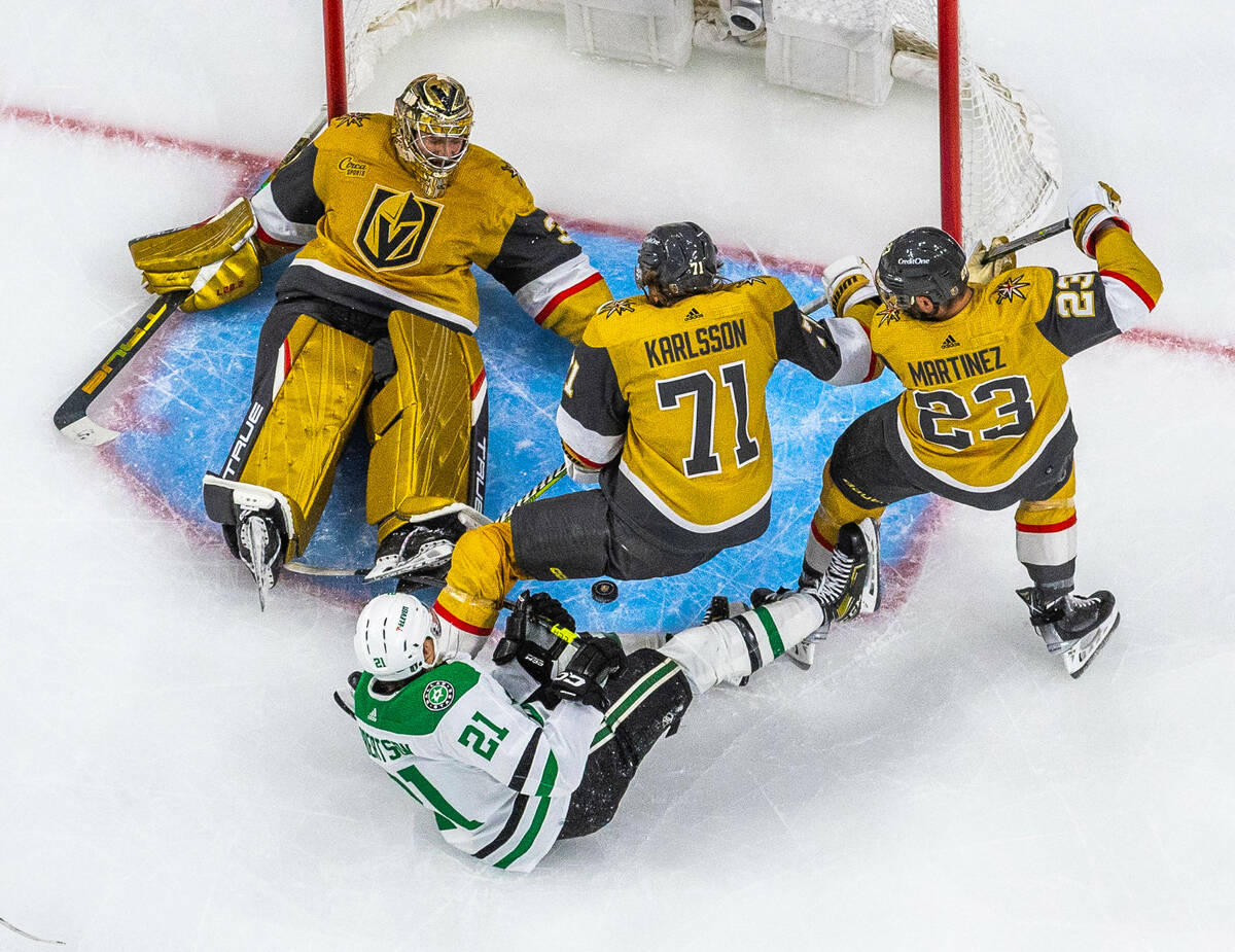 Golden Knights goaltender Adin Hill (33) looks down as the puck enters the crease with a shot a ...