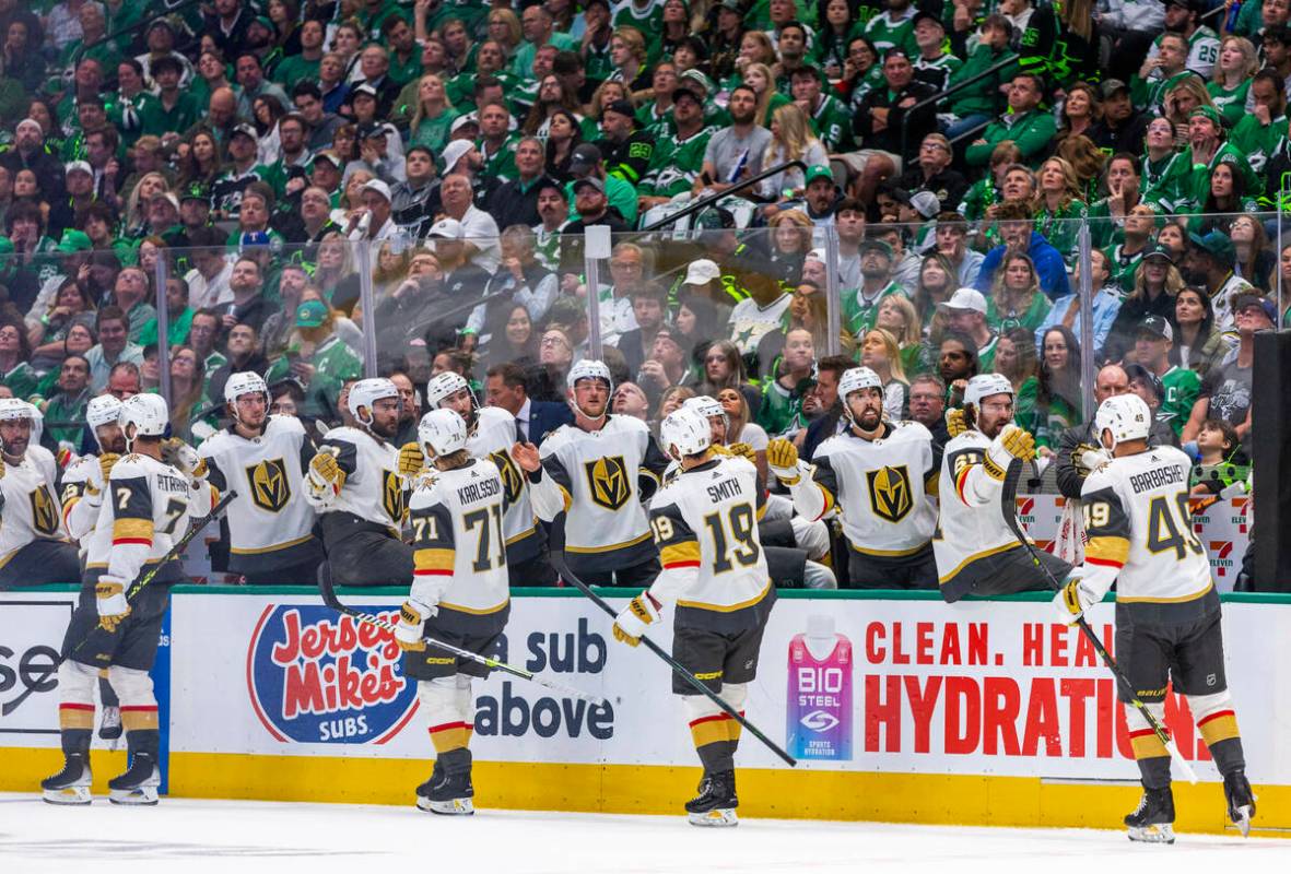 Golden Knights players celebrate their second goal past Dallas Stars goaltender Jake Oettinger ...