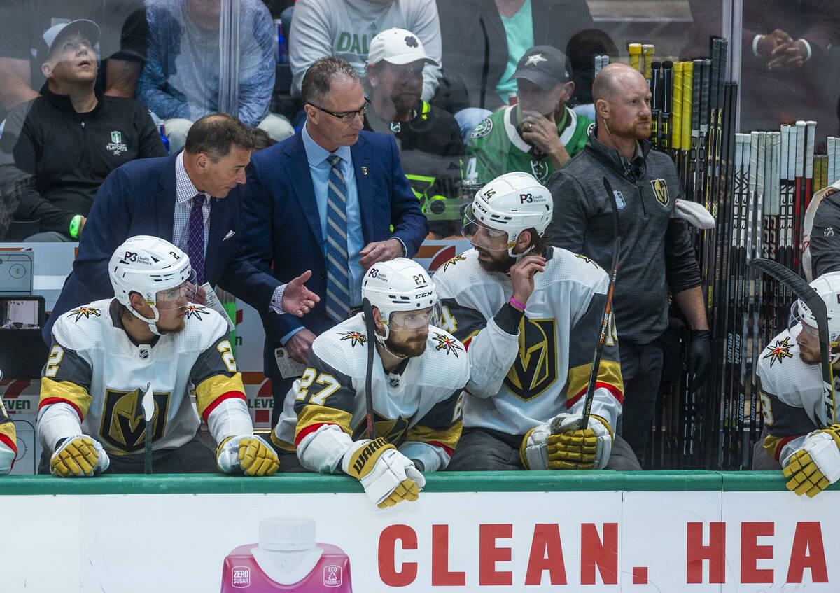 Golden Knights head coach Bruce Cassidy talks to defenseman Nicolas Hague (14) on the bench aga ...