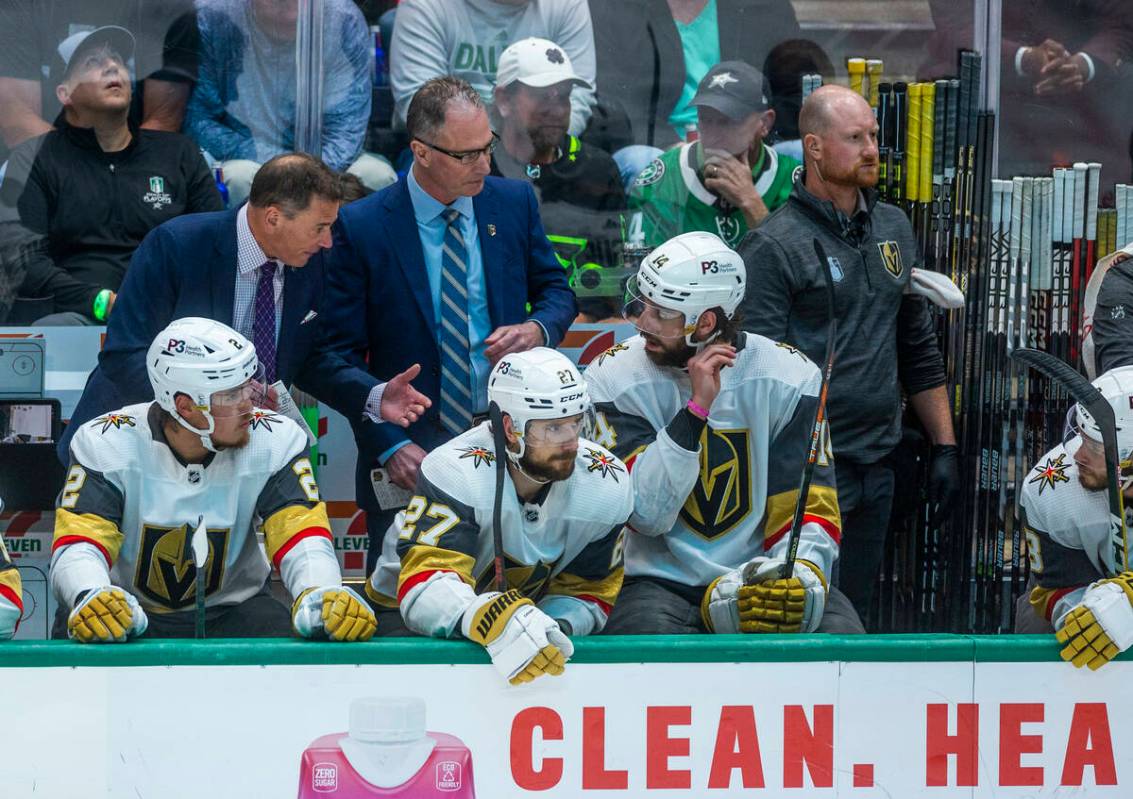 Golden Knights head coach Bruce Cassidy talks to defenseman Nicolas Hague (14) on the bench aga ...